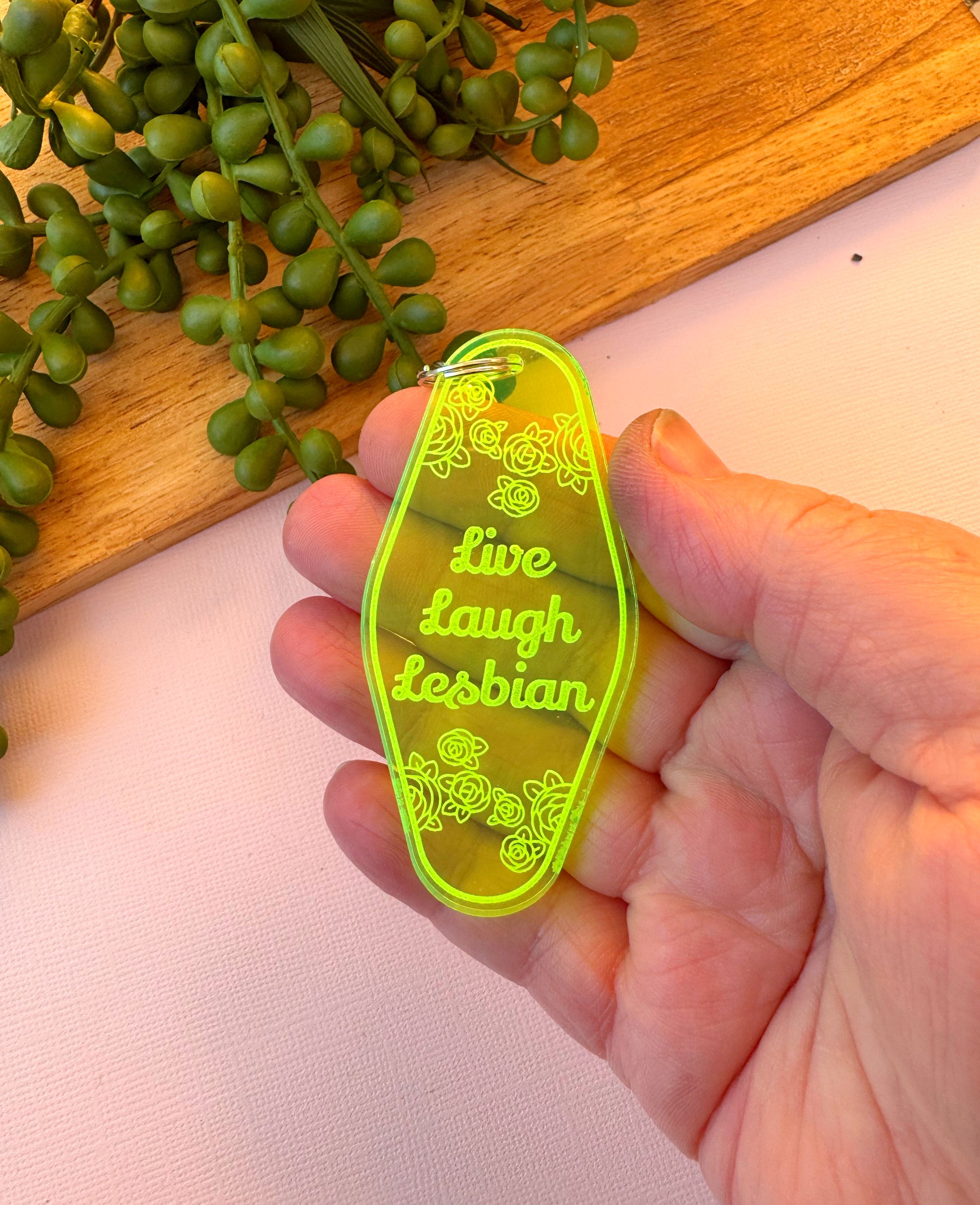 Retro motel-style acrylic keychain with engraved text reading ‘Live Laugh Lesbian,’ handmade and laser-cut with metal lobster clasp.