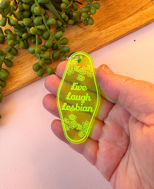 Retro motel-style acrylic keychain with engraved text reading ‘Live Laugh Lesbian,’ handmade and laser-cut with metal lobster clasp.