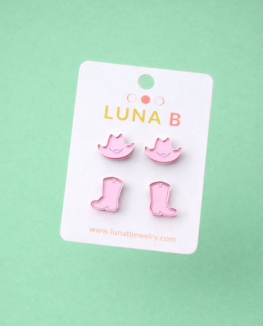 Pink boot-shaped earrings on a Luna B branded card against a light green background