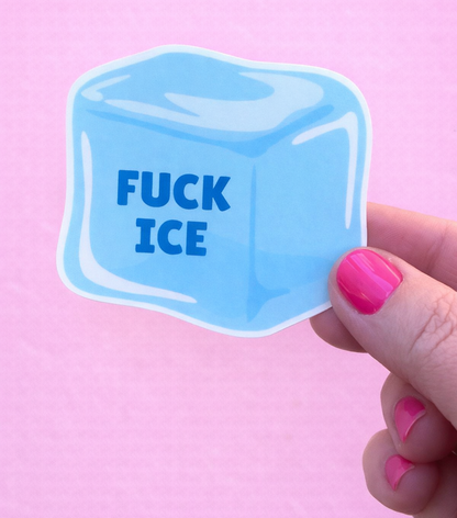 Blue ice cube sticker with 'FUCK ICE' text held by a hand against a pink background