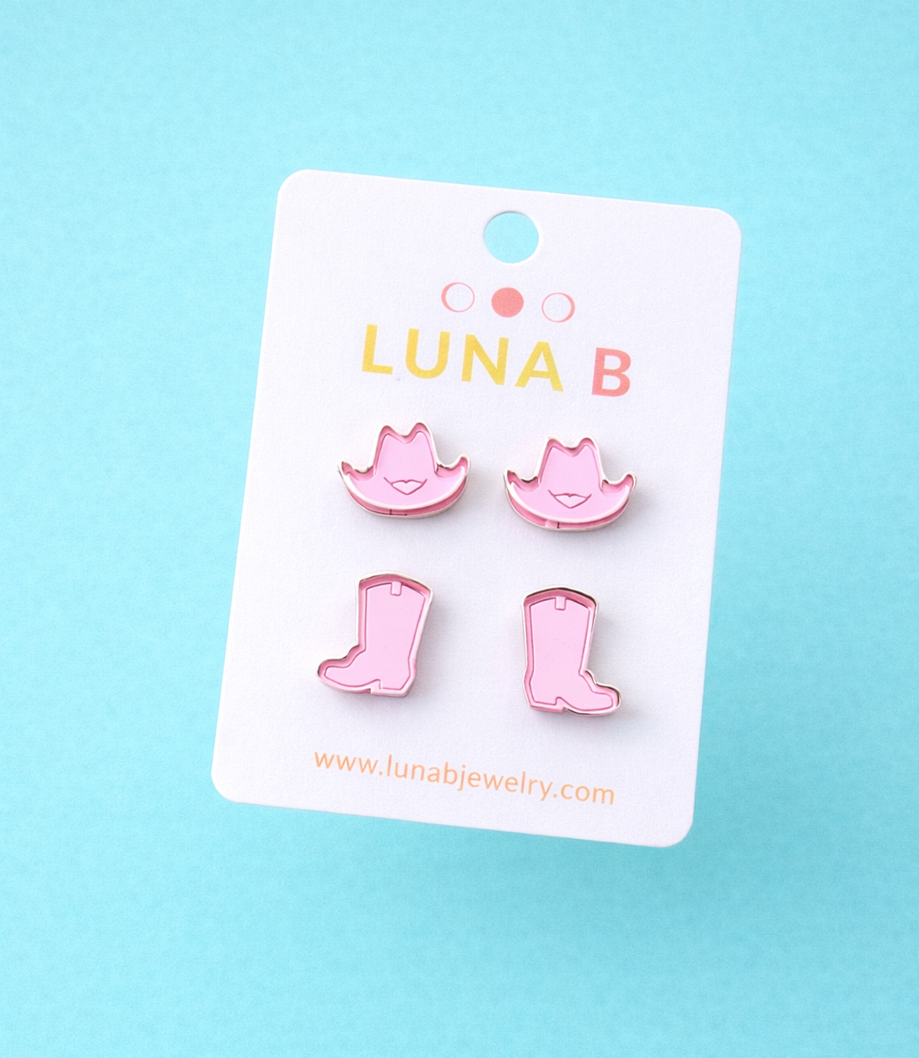 Pink boot-shaped earrings on a Luna B branded card against a light blue background