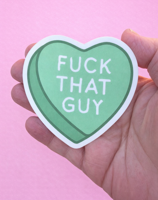 Heart-shaped sticker with text held by a hand against a pink background