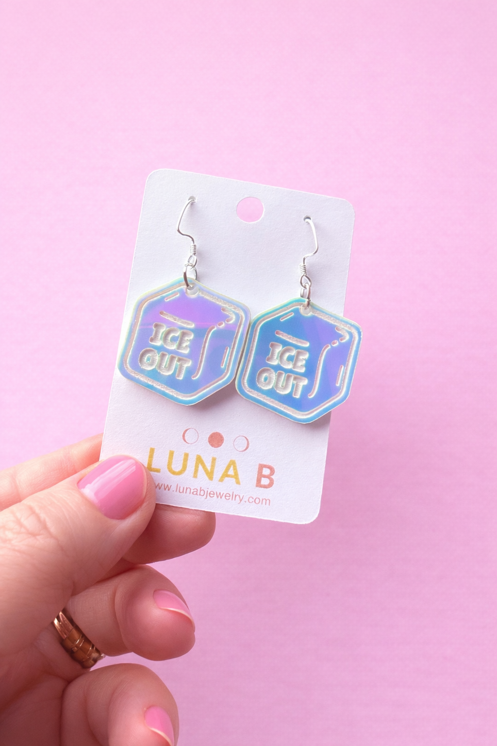 Hexagonal earrings with 'ICE OUT' text on a Luna B branded card against a pink background