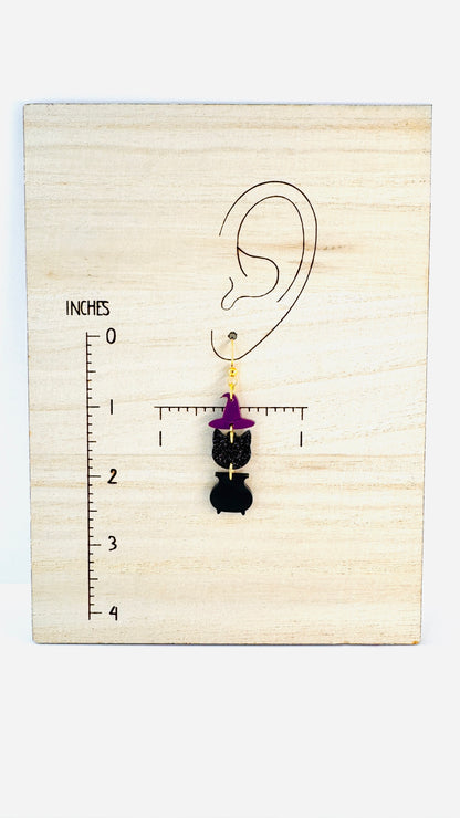Earring displayed on a wooden block with an ear illustration and measurement scale.