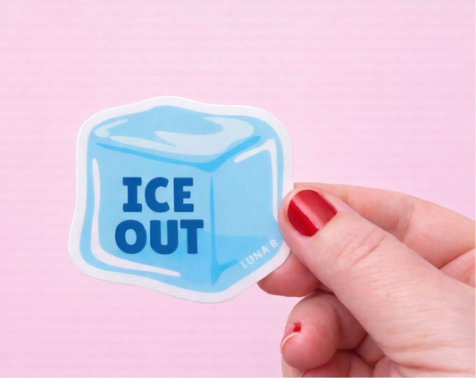 Sticker of an ice cube with 'ICE OUT' text held by a hand against a pink background