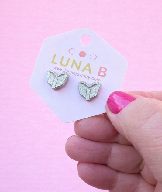 silver book-shaped earrings on a Luna B card with a pink background