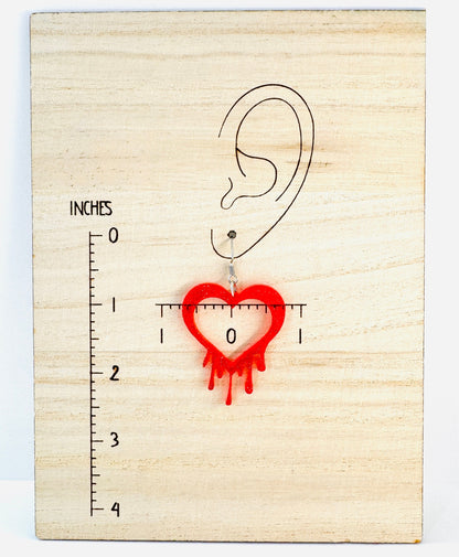 Wooden ear gauge with a heart-shaped hole and measurement scale on a light wood background