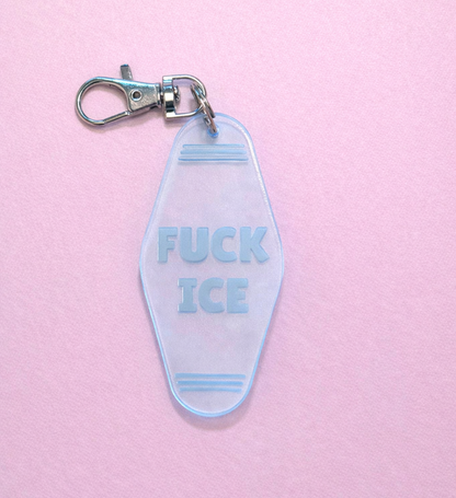 Clear motel keychain with blue text on a pink background