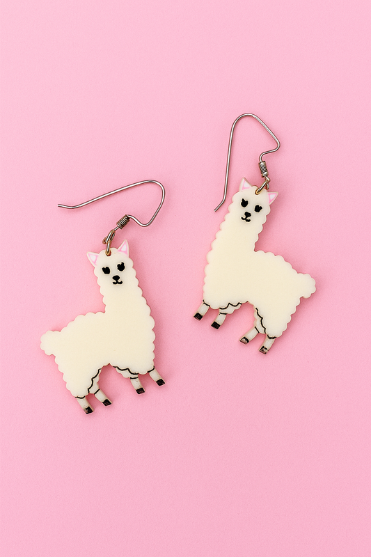 White llama-shaped earrings on a pink background