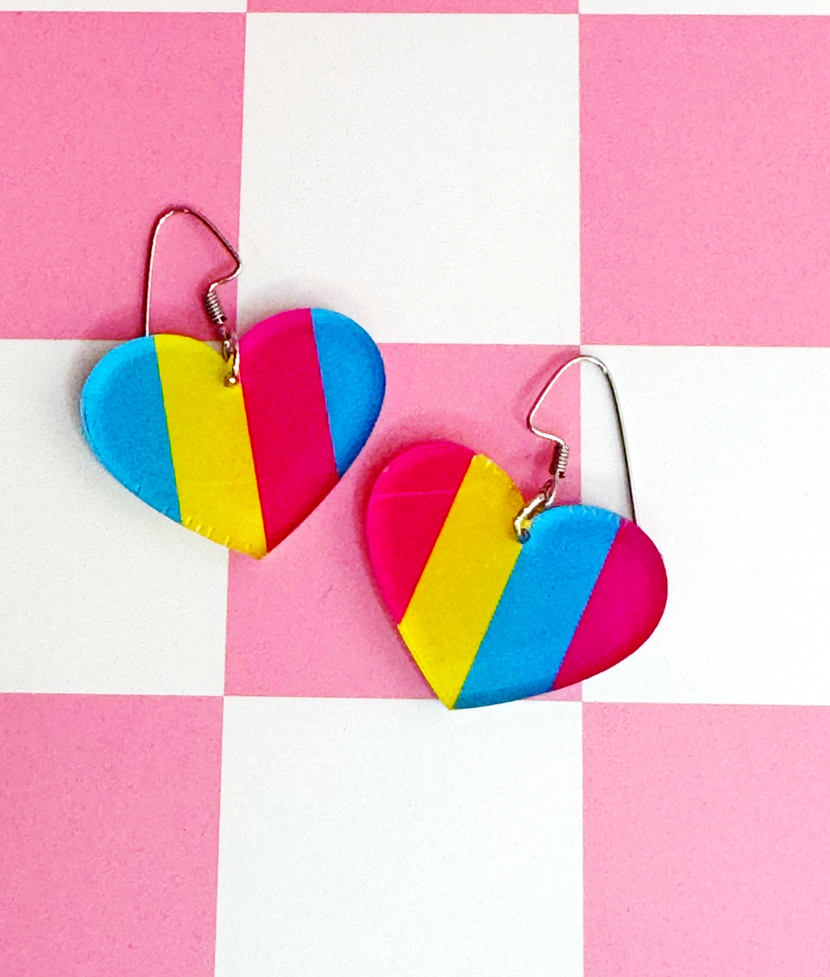 Handmade laser-cut acrylic earrings in pansexual Pride colors—pink, yellow, and blue—set on hypoallergenic stainless steel ear wires.